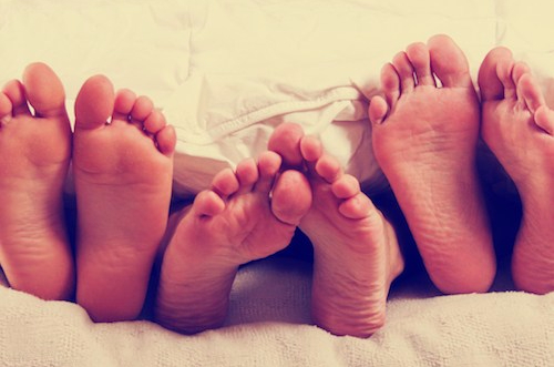 three+sets+of+feet+in+bed